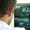 Video broadcast editor with headphones at screen